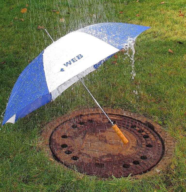 Wasser fällt einen Regenschirm