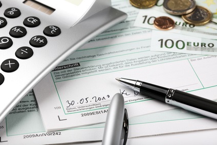 Taschenrechner, Kugelschreiber und Geld auf einem Steuerformular