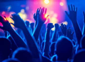People raise their hands at a music concert