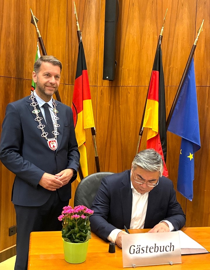 Mayor Dennis Weilmann (left) with his guest signing the city's guest book