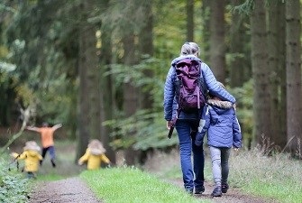Eine Frau und ein Kind gehen auf einem Waldweg spazieren