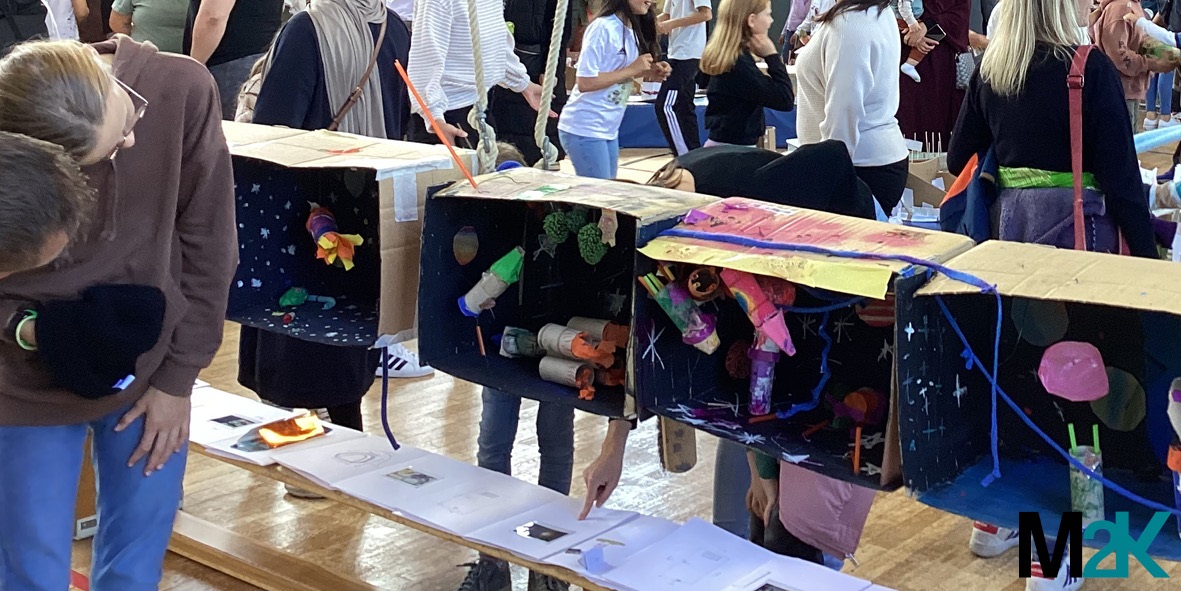 Ausstellungsbesucher*innen betrachten planetarische Räume der 2. Klassen.