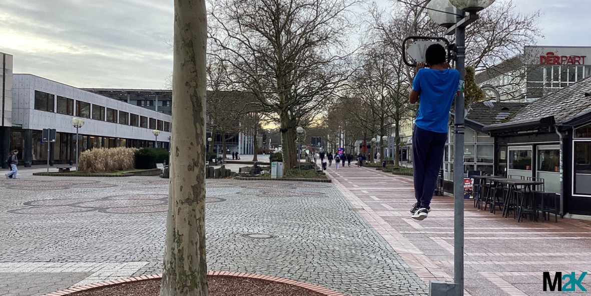 Pictures in public space - A person hangs on a lamppost.
