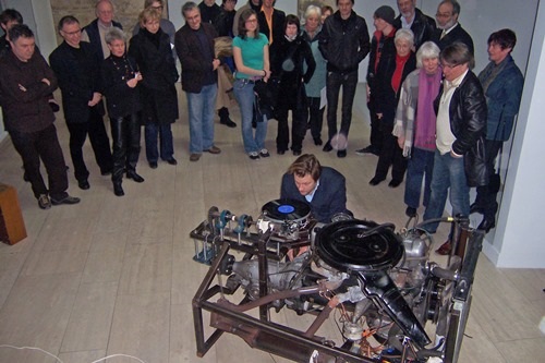 Eine Besuchergruppe schaut sich das Kunstwerk "Plattenspieler" an