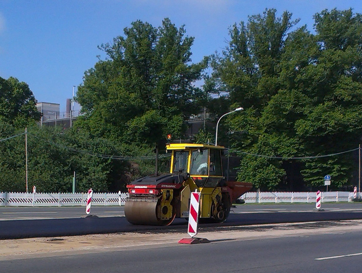 Eine Planierraupe walzt einen neuen Straßenbelag