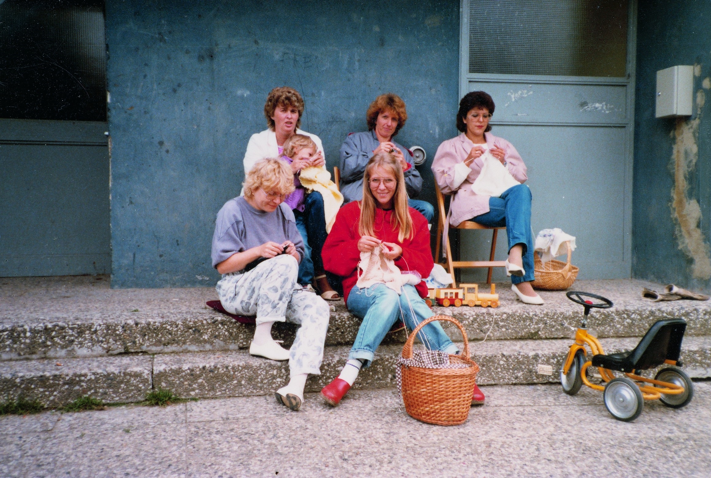 Eine Gruppe von Frauen sitzt auf einer Treppe vor einem Gebäude