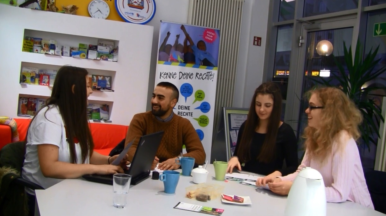 Jugendliche sitzen an einem Tisch