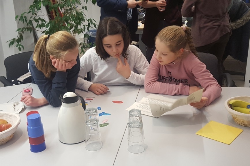 Kinder sitzen an einem Tisch