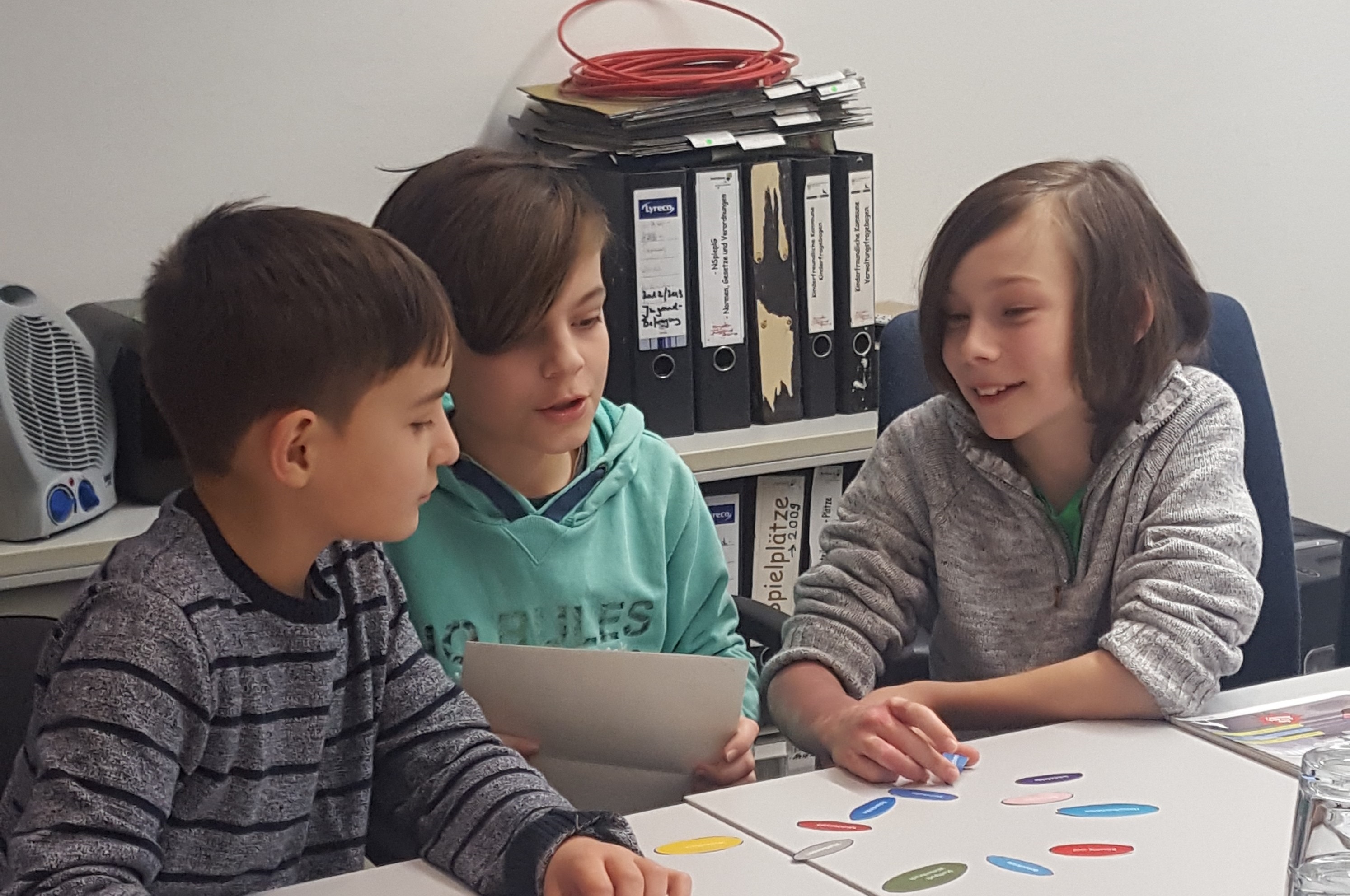 Kinder sitzen an einem Tisch