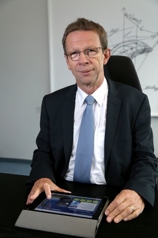 Oberbürgermeister Klaus Mohrs sitzt mit dem IPad am Schreibtisch