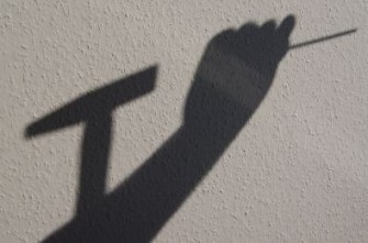 Schatten einer Hand und eines Hammers; Foto: Holger Rausch / pixelio.de