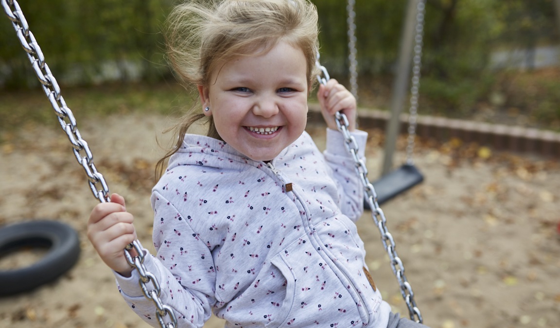 Ein Kita-Kind schaukelt