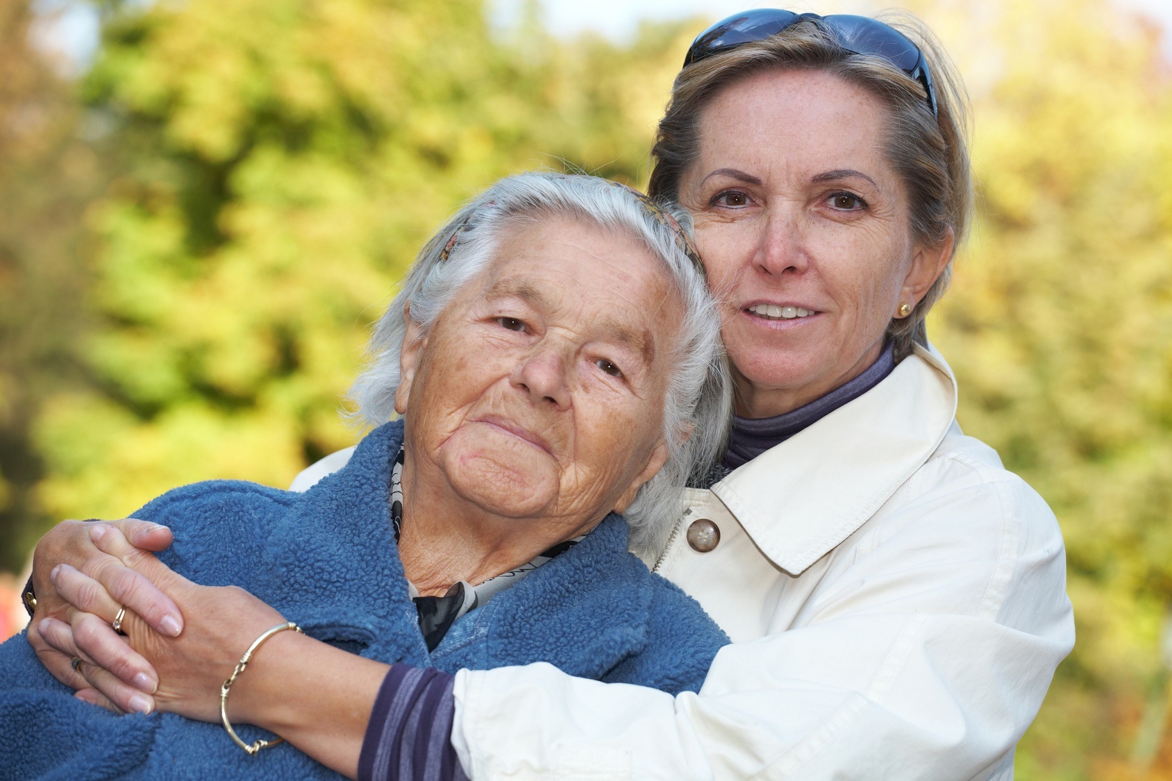 Zwei ältere Damen halten einander in den Armen