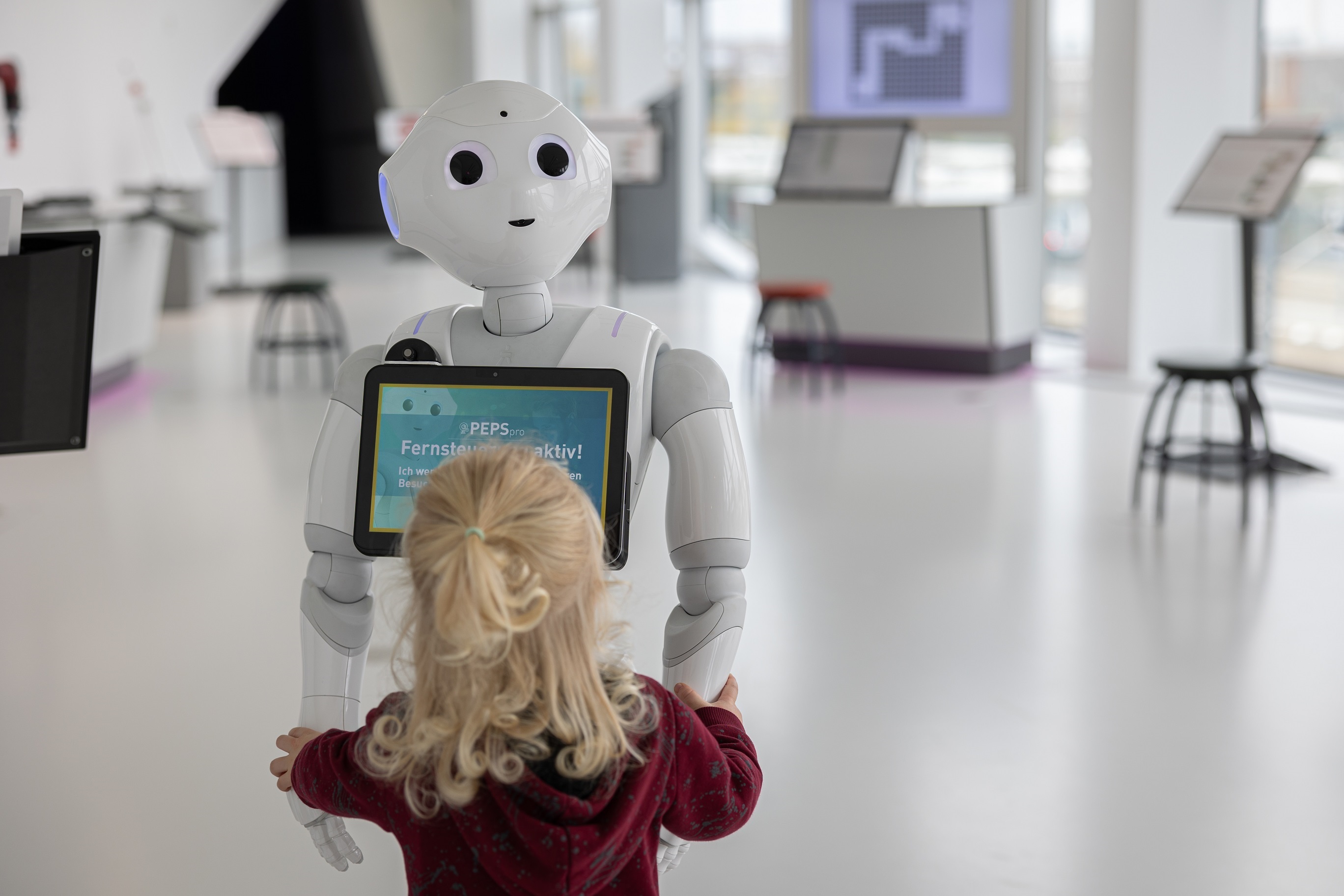 Mädchen vor einem Roboter in der Ausstellung smarte Welten