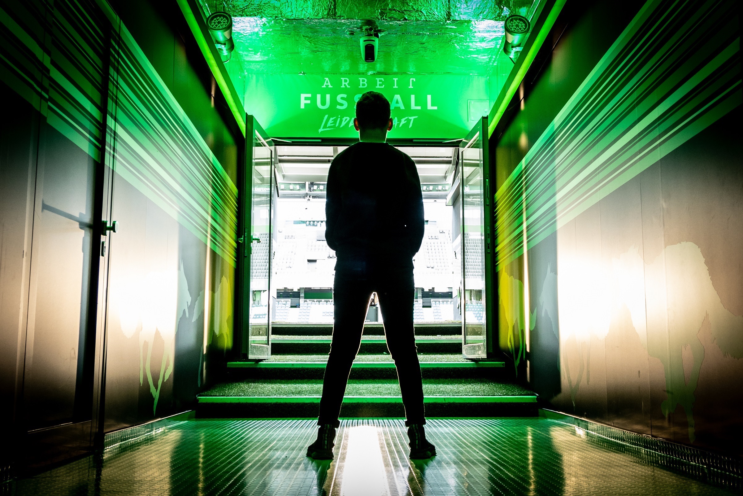 Ein Junge steht im Spielertunnel der Volkswagen Arena