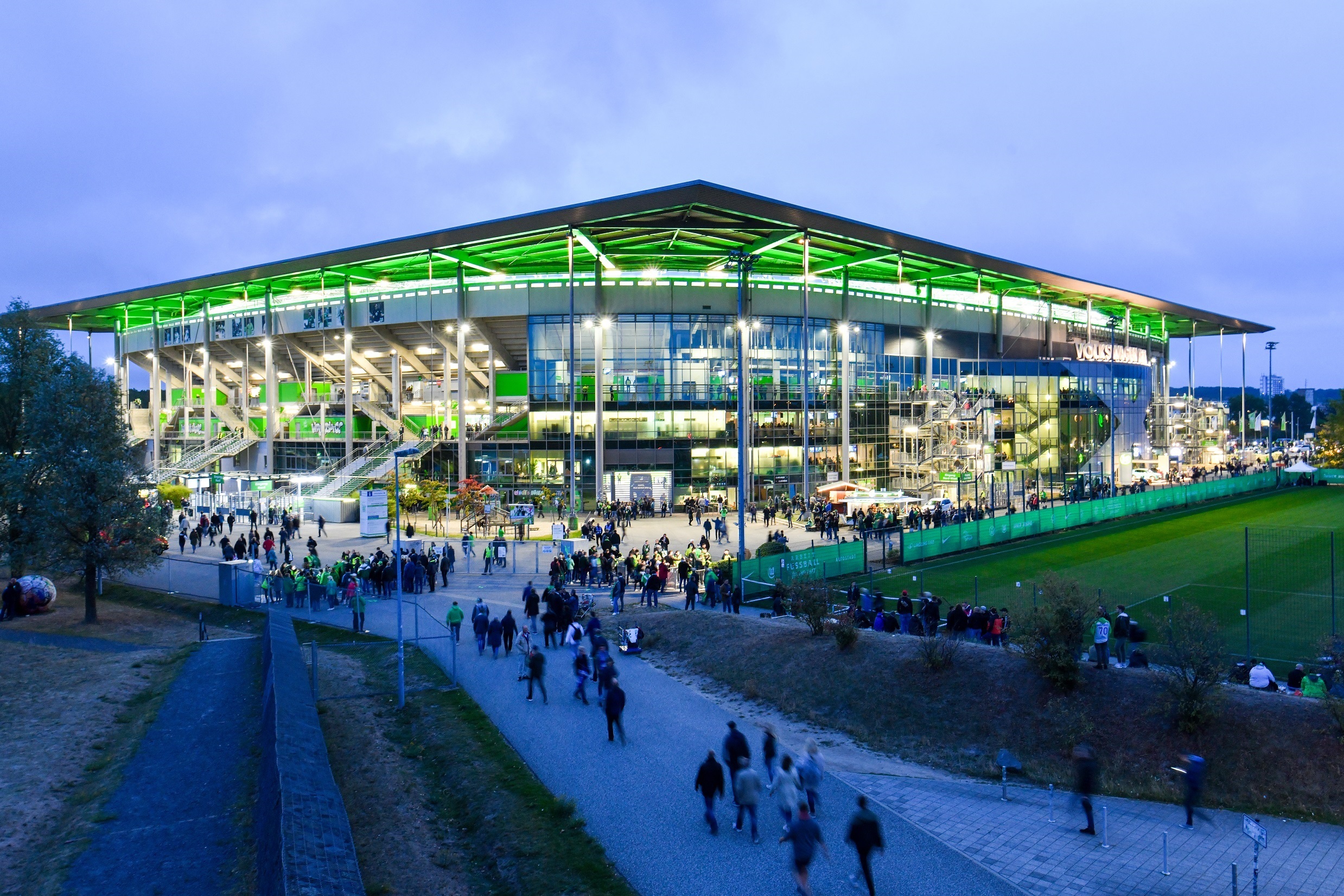 Volkswagen Arena in der Abenddämmerung an einem Spieltag mit Fans